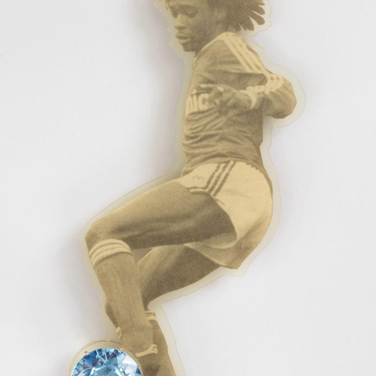 Gijs Bakker, "Blinker Brooch" from the "Sportfiguren (Sports Figures)" series, 1988, executed by Tobias van Roojen, gold, aquamarine and PVC-laminated newspaper; 6 1/2 in x 2 9/16 in x 11/16 in.