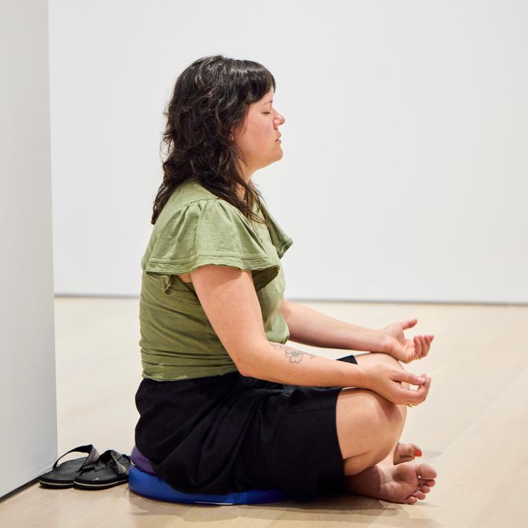 MOA visitor meditating in gallery
