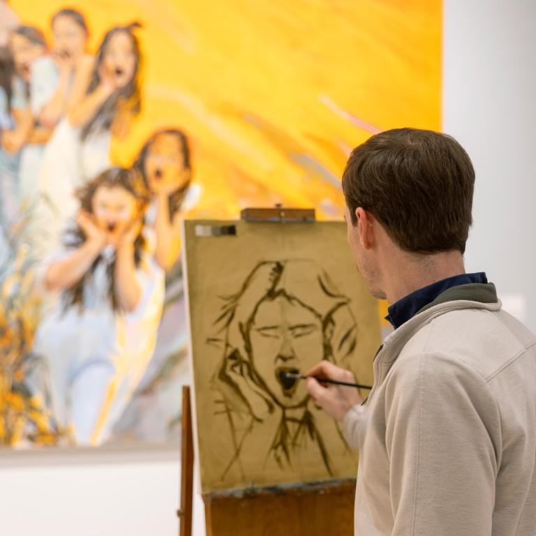 person painting at an easel